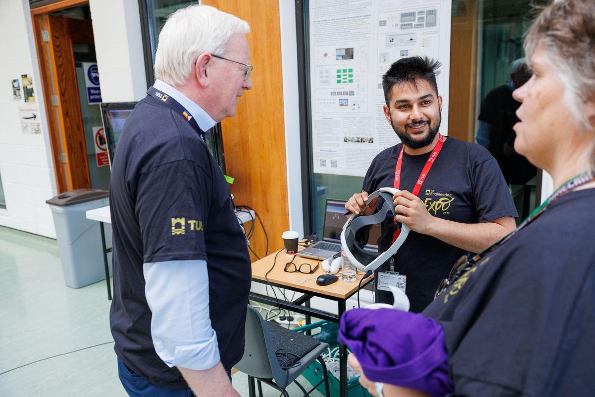 Sahir Sharma demonstrating a mixed reality headset to a visitor.
